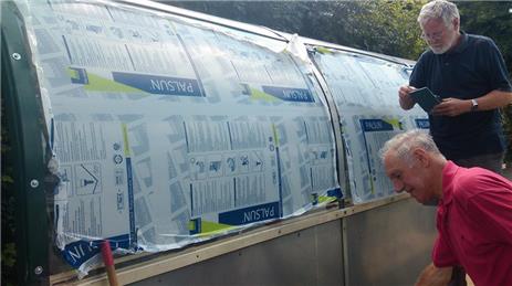The Men in Sheds inserting the new perspex - Station bus shelter repaired