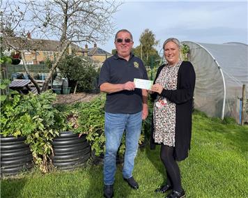 Pete Butler handing over the vouchers to Charlie Blades for there garden projects at Partney - Donations to Primary Schools